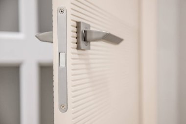 Modern iç mekanda manyetik kilidi olan metal kapı kolu.