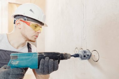 İnşaatçı işçi pnömatik çekiç delme delikleri beton tuğla duvar ve elektrik kablosu için elmas taç, soket, anahtar
