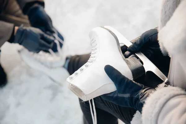 Homem ajuda a colocar patins para rinque de gelo neve para menina, conceito de férias de inverno, descanso familiar — Fotografia de Stock