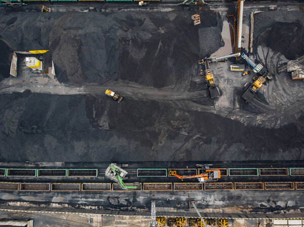 Loading coal anthracite mining in port on cargo tanker ship with crane bucket of train. Aerial top view
