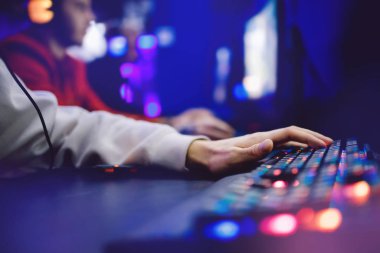 Kişisel bilgisayar koltuğu olan profesyonel sanal video oyunu stüdyosu, neon renkli arka planda akış için klavye, yumuşak odaklı