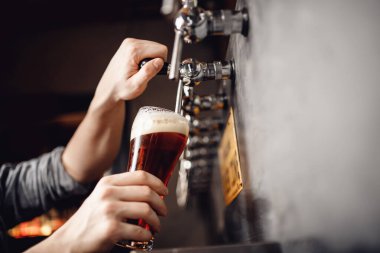 Barmen bardaktan siyaha bira döker. Alkol zanaatı içki konsepti