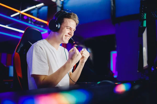 Streamer junger Mann freut sich über den Sieg professionelle Gamer spielen Online-Spiele Computer mit Kopfhörern, Neonfarbe — Stockfoto