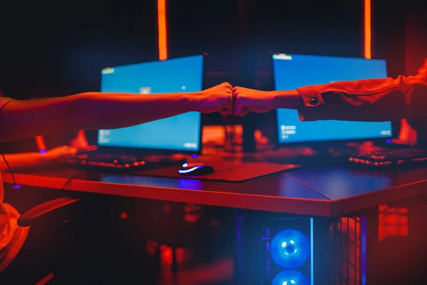 Professional gamer saluto e supporto pugno squadra mani gioco online in colore neon sfondo sfocatura. Focus morbido, vista posteriore — Foto Stock