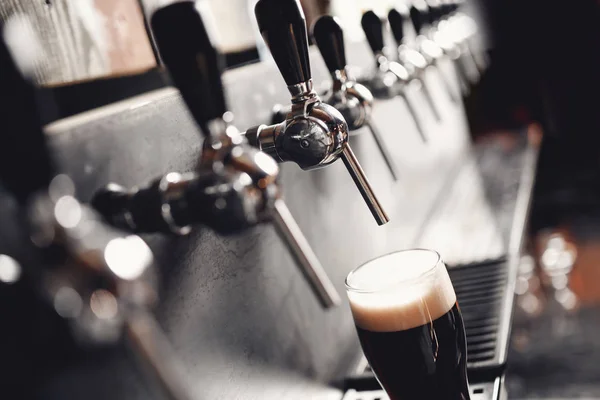 Light Draft koud bier giet in glas van kraan in pub — Stockfoto