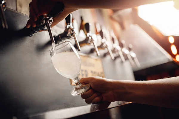 Il barman versa il sidro alcolico leggero di barilotto nel bicchiere. Sfondo scuro — Foto Stock