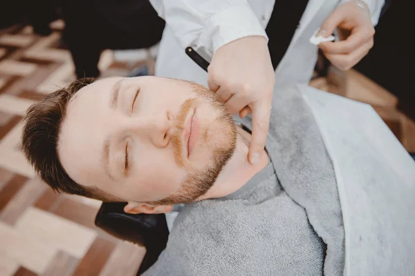 Barbiere processo rasatura rasoio barbuto hipster uomo in barbiere — Foto Stock