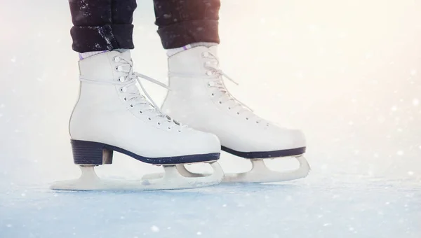 Menina está em pé no gelo em patins figura branca, flocos de neve. Inverno conceito férias ativas — Fotografia de Stock