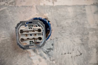 Patlama duvarındaki parçalanmış elektrik prizi. Dairenin tamiri sırasında çıplak kablolar ve işaretlerle.