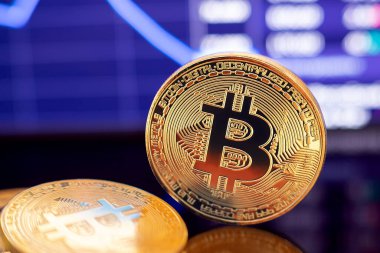 Grafik diyagramının arka planında altın Bitcoin kripto para birimi