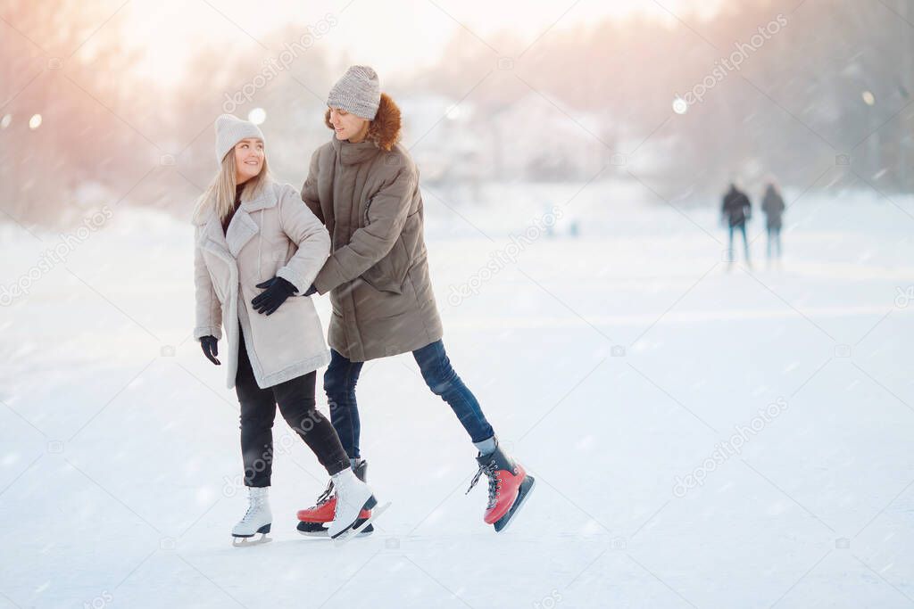 Ice skating lover couple having fun on snow winter holidays