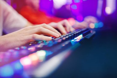 Bulanık arka plan profesyonel oyuncu turnuva oynuyor çevrimiçi oyun bilgisayarı kulaklıklı, kırmızı ve mavi