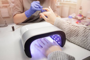 Kapalı kapılar ardında güzellik salonunda manikür yaptıran güzel eller.