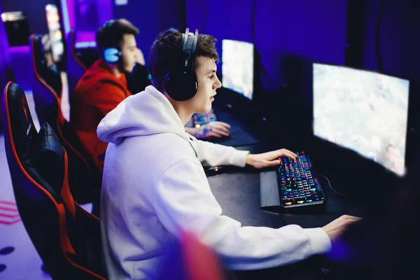 Jogador profissional jogando torneios online computador de jogos de vídeo com fones de ouvido, vermelho e azul — Fotografia de Stock