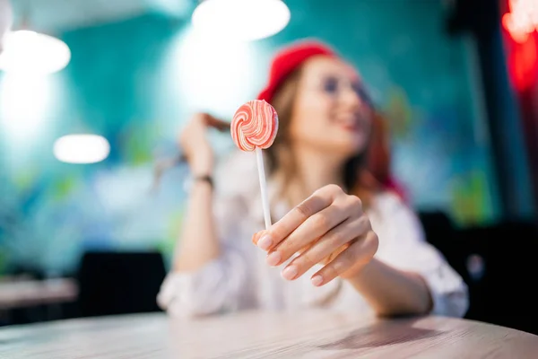 Menina comendo pau pegajoso doce na França café em boina vermelha e óculos. Cárie conceito e dano é perigo para o esmalte dentário — Fotografia de Stock