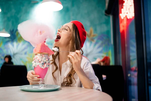Francia dulce postre nacional, chica en boina roja come pastel rosa, hilo de caramelo y batido, risas y sonrisas — Foto de Stock