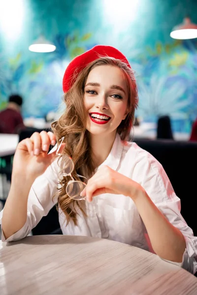 Retrato jovem menina frança retro feliz em boina vermelha e camisa branca com sorriso branco-neve, café da manhã no café — Fotografia de Stock