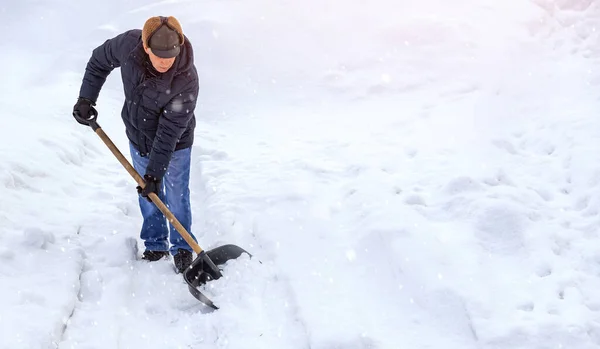 Man cleaning snow winter with shovel after snowstorm yard sunlight — 스톡 사진