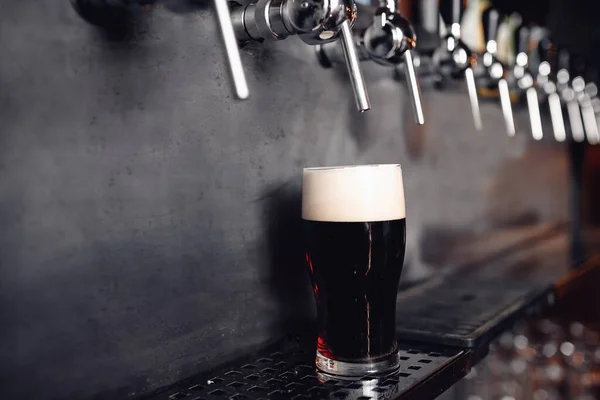 Bier tikt rauw in de pub. Selectieve focus, donkere achtergrond — Stockfoto