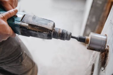 Elektrik prizi için çekiç matkaplarıyla duvarda sıkıcı bir delik