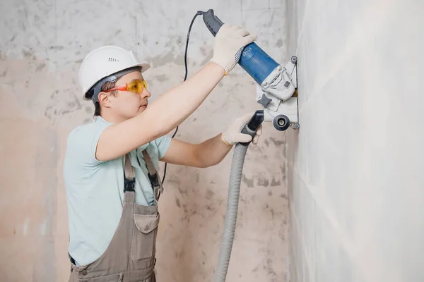 Builder worker cutting electrical chase in concrete wall with circulation saw drill diamond crown — Stock Photo, Image