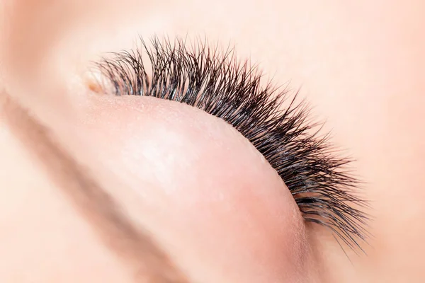 Mujer foto macro con pestañas largas en el salón de belleza. Concepto procedimiento de extensión de pestañas — Foto de Stock