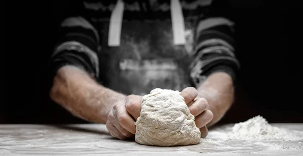 Manos de panadero macho preparando masa de levadura con polvo de harina blanca sobre fondo negro, sacar para pasta y pizza — Foto de Stock