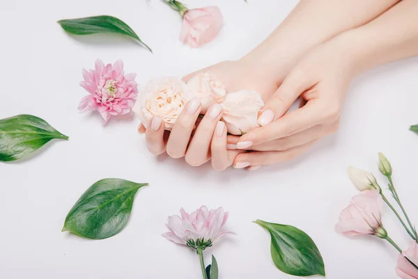 Concept schoonheid huidverzorging. Mooie stijlvolle vrouwelijke roze manicure met bloem op achtergrond, bovenaanzicht — Stockfoto