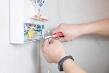 Electrician mounts consumer electric switchboard control panel for home enclosure for distribution and power electricity