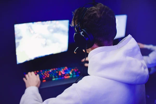 Επαγγελματίας gamer που παίζει τουρνουά σε απευθείας σύνδεση βίντεο παιχνίδια υπολογιστή με ακουστικά, κόκκινο και μπλε — Φωτογραφία Αρχείου