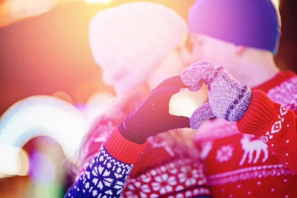 Woman and man hands in winter gloves heart symbol. Concept feelings love and freedom with sunset night background bokeh — Stock Photo, Image