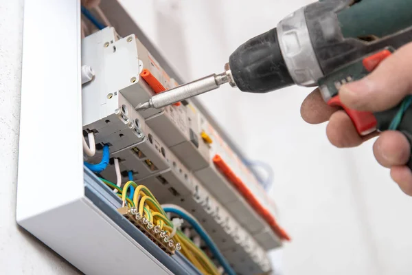 Electrician mounts consumer electric switchboard control panel for home enclosure for distribution and power electricity — Stock Photo, Image