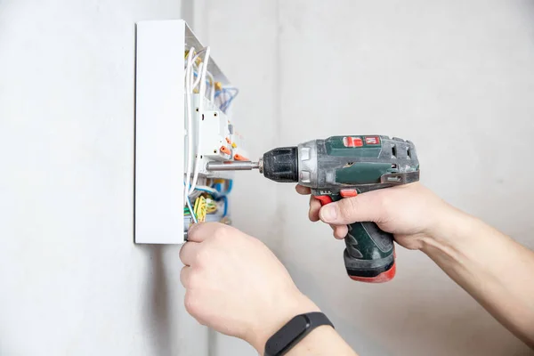 Electrician hand mounts consumer electric control panel switchboard for home enclosure for distribution and power electricity — Stock Photo, Image