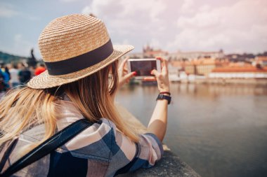 Young woman happy with backpack tourist taking selfie photo camera on Charles Bridge in Prague, Czech Republic. Concept travel