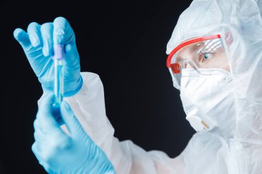 Beyaz tehlikeli madde koruma araştırma görevlisi modern laboratuvarda kan testi yapıyor. Mavi renk, korona virüsü salgını