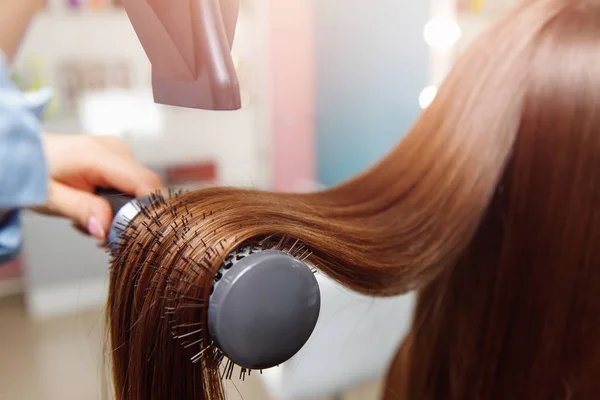 Brillo Secado cabello castaño largo con secador y cepillo redondo después del tratamiento de Spa. Maestro femenino —  Fotos de Stock
