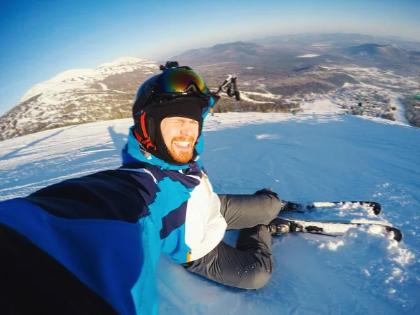 Selfie Guy sportsman goes on normal skiing on ski slope with action camera Sheregesh