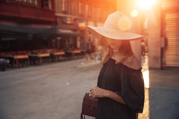 Привлекательная женщина в шляпе широкий край на улице летний город с эффектом солнечного света — стоковое фото