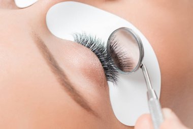 Makro kirpik uzatma prosedürü. Kadın usta tarakları kirpikleri