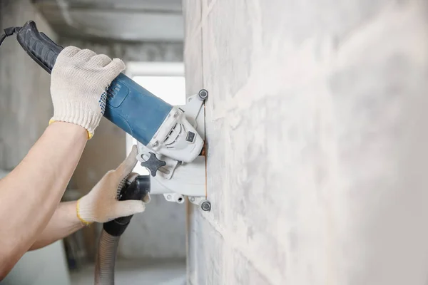 Stavební dělník řezání elektrické honičky v betonové stěně s cirkulační pilou diamantová koruna — Stock fotografie