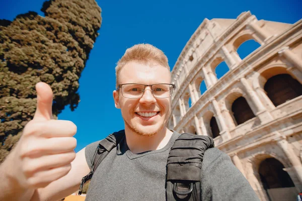 Homem feliz turista com mochila com óculos tirando foto selfie Coliseu em Roma, Itália — Fotografia de Stock