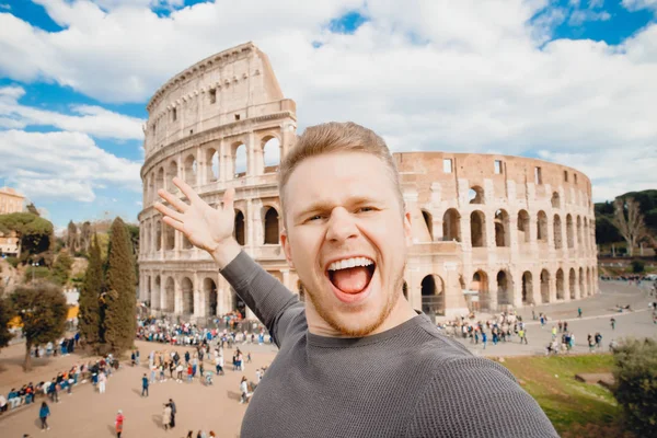 이탈리아 로마의 콜로세움에서 셀카를 만들고 미소짓는 행복 한 청년. 개념 여행 — 스톡 사진