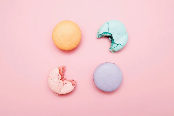 Minimalismo, macaroons mordidos no fundo rosa, vista superior. Conceito de redução das taxas de juro dos empréstimos nos bancos, impostos — Fotografia de Stock