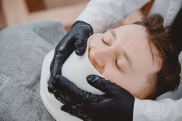 Barbiere vapore faccia pelle di uomo con asciugamano caldo prima rasatura reale in Barbiere — Foto Stock