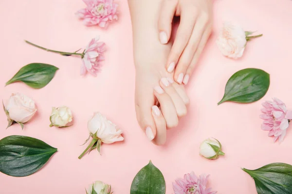 Konzept Handpflege, Anti-Falten, Anti-Aging-Creme, Wellness. Close-up schöne anspruchsvolle weibliche Hände mit rosa Blumen auf weißem Hintergrund — Stockfoto