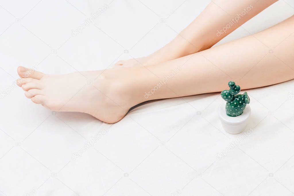 Process depilation of legs girl with sugar paste in spa salon, white background. Shugaring hair removal concept. Top view