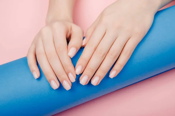 Closeup Elegante manicure prego mulheres mãos sobre fundo rosa e azul, vista superior — Fotografia de Stock