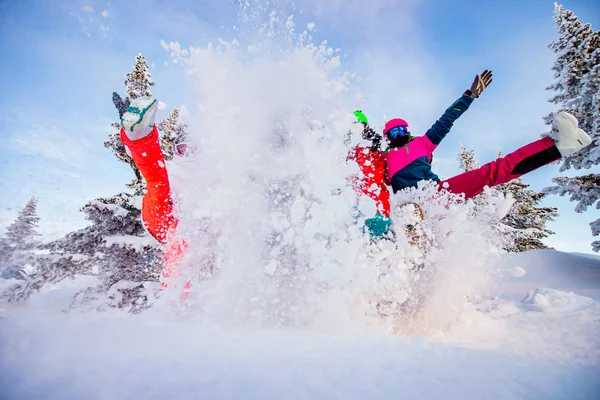 Boldog csapat snowboardosok és síelő szórakozás dobált hó. Könnyű nap a téli erdőben napkelte — Stock Fotó