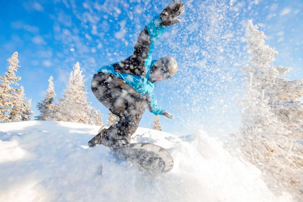 Actieve man snowboarder rijden op de helling tijdens zonnige dag in de bergen. Stof sneeuwwoud — Stockfoto