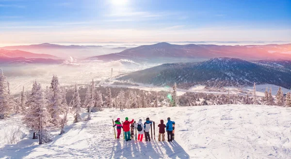 Mutlu snowboardcular ve kayakçılar eğleniyor ve snowboard 'larla poz veriyor ve güneşin doğuşunda kayak yapıyor. Havadan üst görünüm — Stok fotoğraf